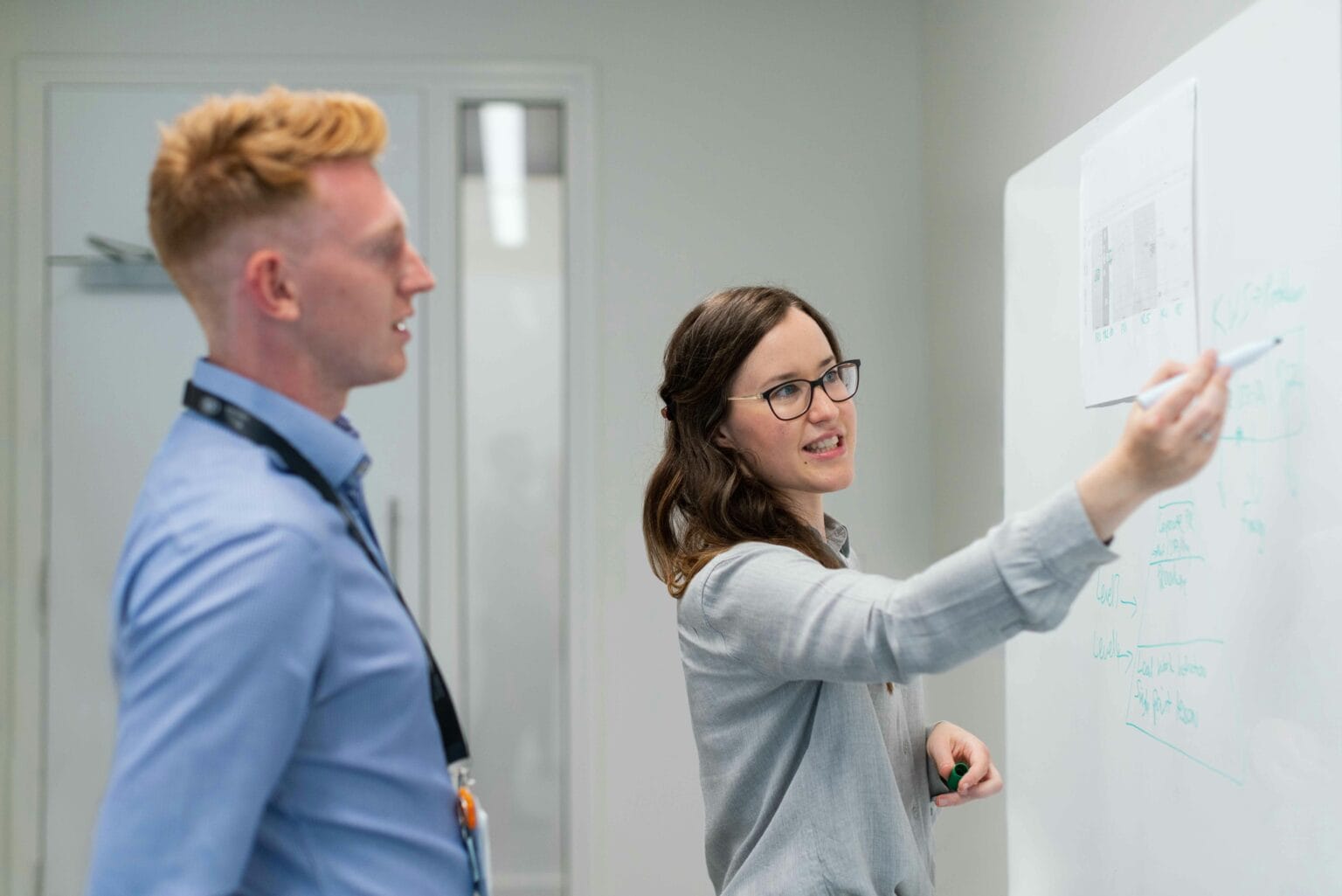 Mentor guiding a learner at a whiteboard